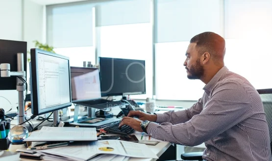 photo-id-2002016600133-businessman-working-on-computer-at-his-desk-in-office photo-id-2002016600133-businessman-working-on-computer-at-his-desk-in-office